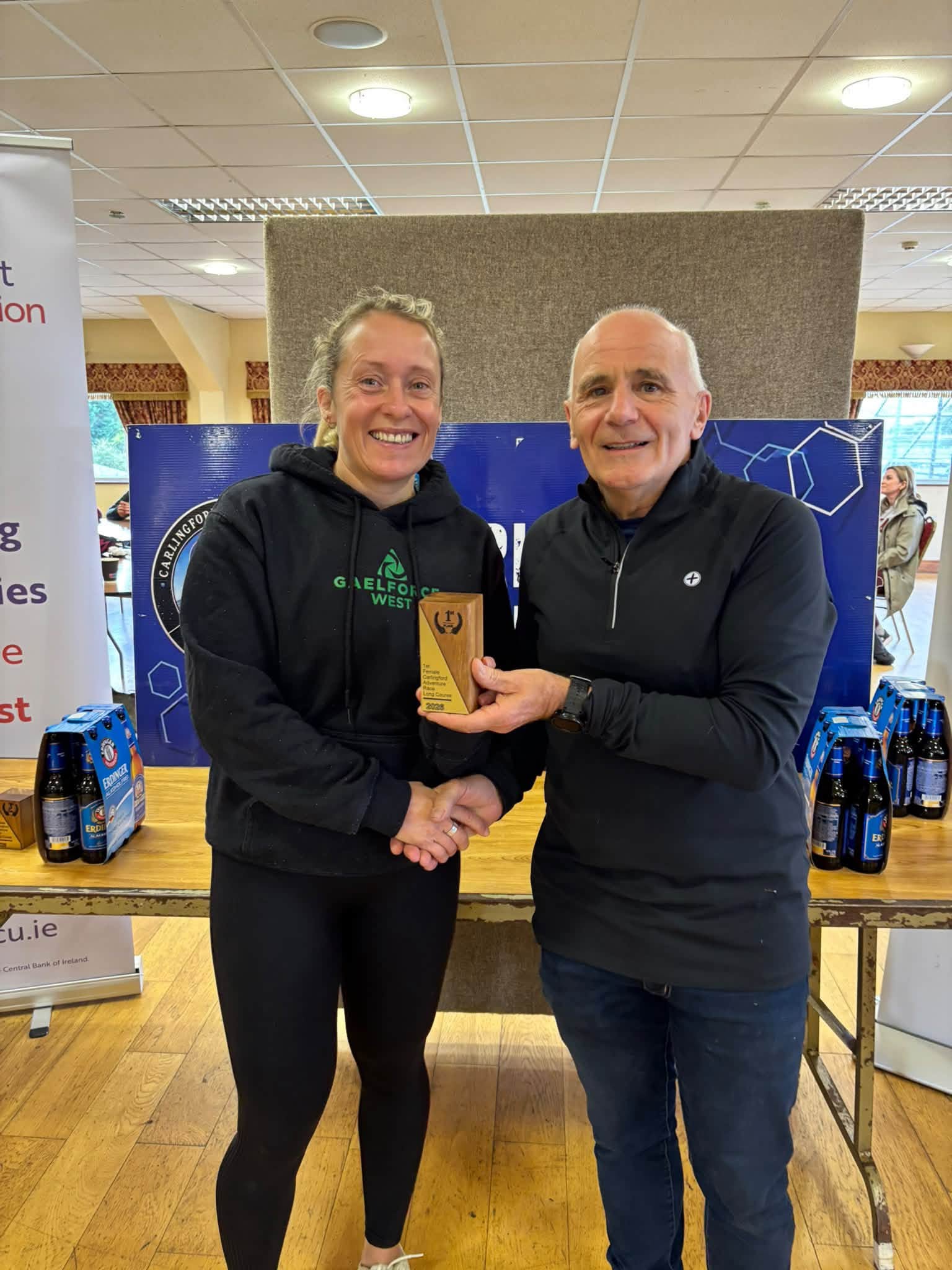 Prize giving: a winner in a black hoodie is presented with a trophy