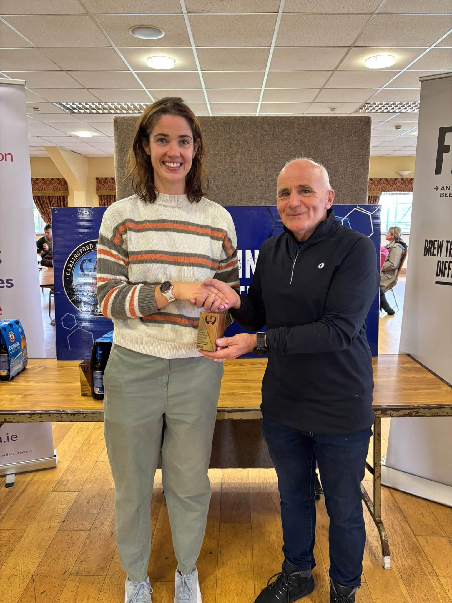 Prize giving: a winner in a striped jumper is presented with a trophy